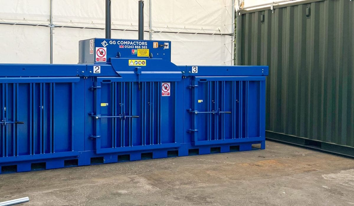 Cardboard baling machine under a large tarpaulin