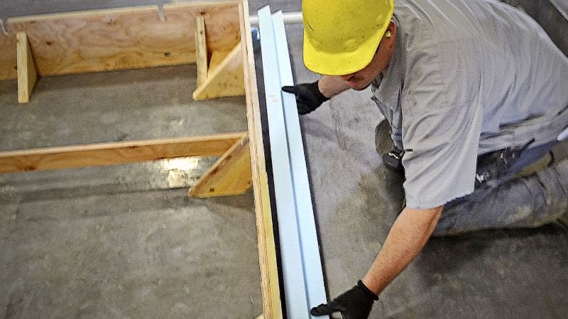 Man bonding high density foam to a wooden frame