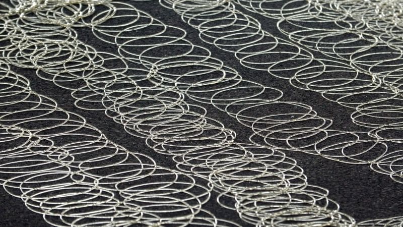 Spray pattern from a Tec hot melt glue gun on a dense dark foam