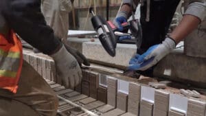 Workmen applying Casttec adhesives to some riser panels on a concrete form.