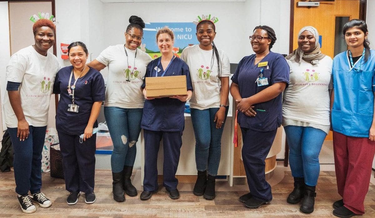 Group of nurses and support workers holding a box full of gifted materials