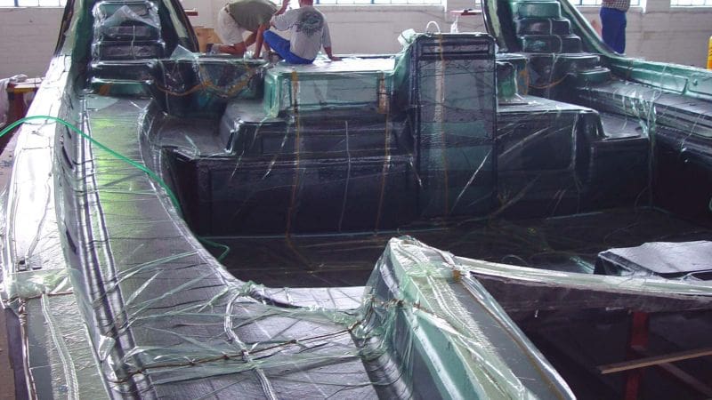 Boat hull being infused with resin to harden the material layers