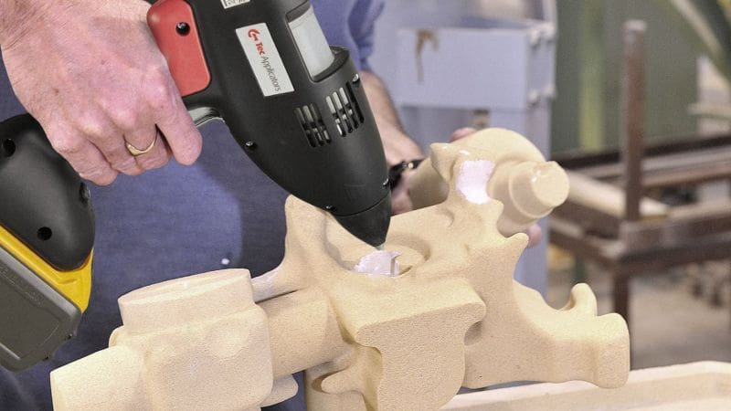 Hot melt adhesive being added to a large section of sand core