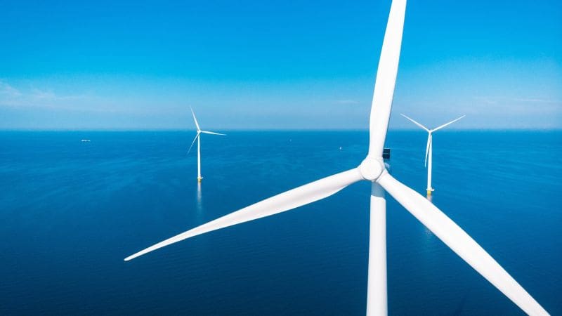 Offshore wind farm with a bright blue sky behind