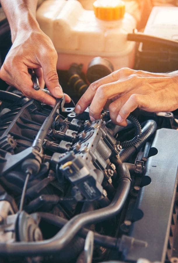 Mechanic servicing a vehicle. Working in an engine bay.
